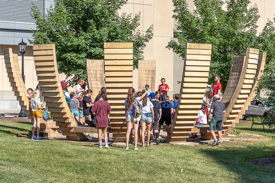 A group of precollege students hanging out on the lawn outside Gordon's dining center