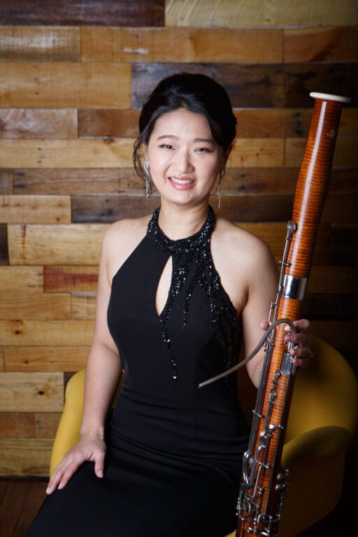 A woman posing for a picture with her instrument