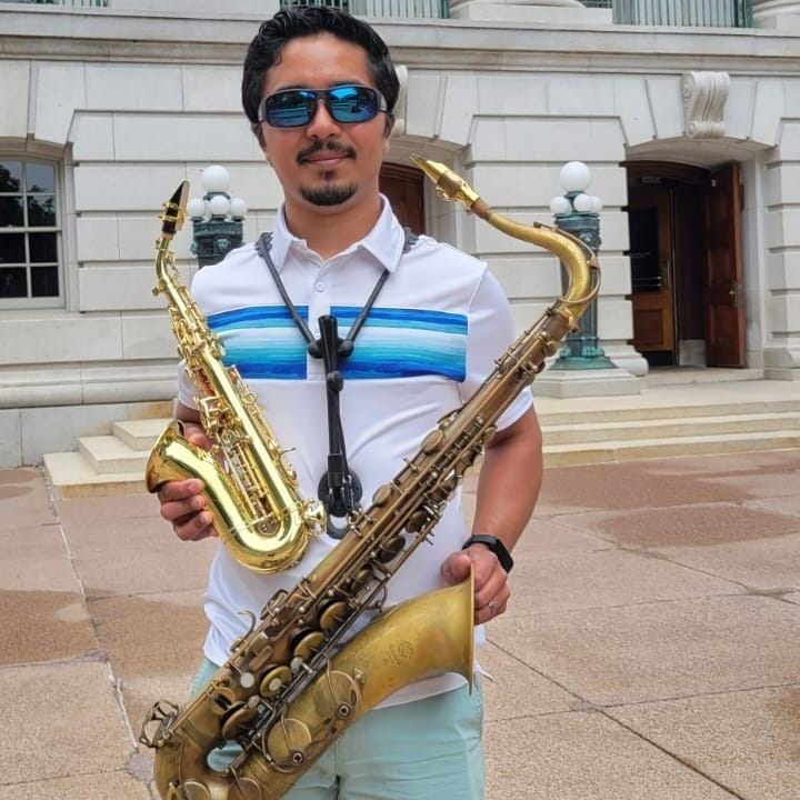 A picture of a man posing with his two instruments