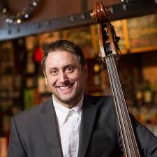 A man posing for a picture with his bass
