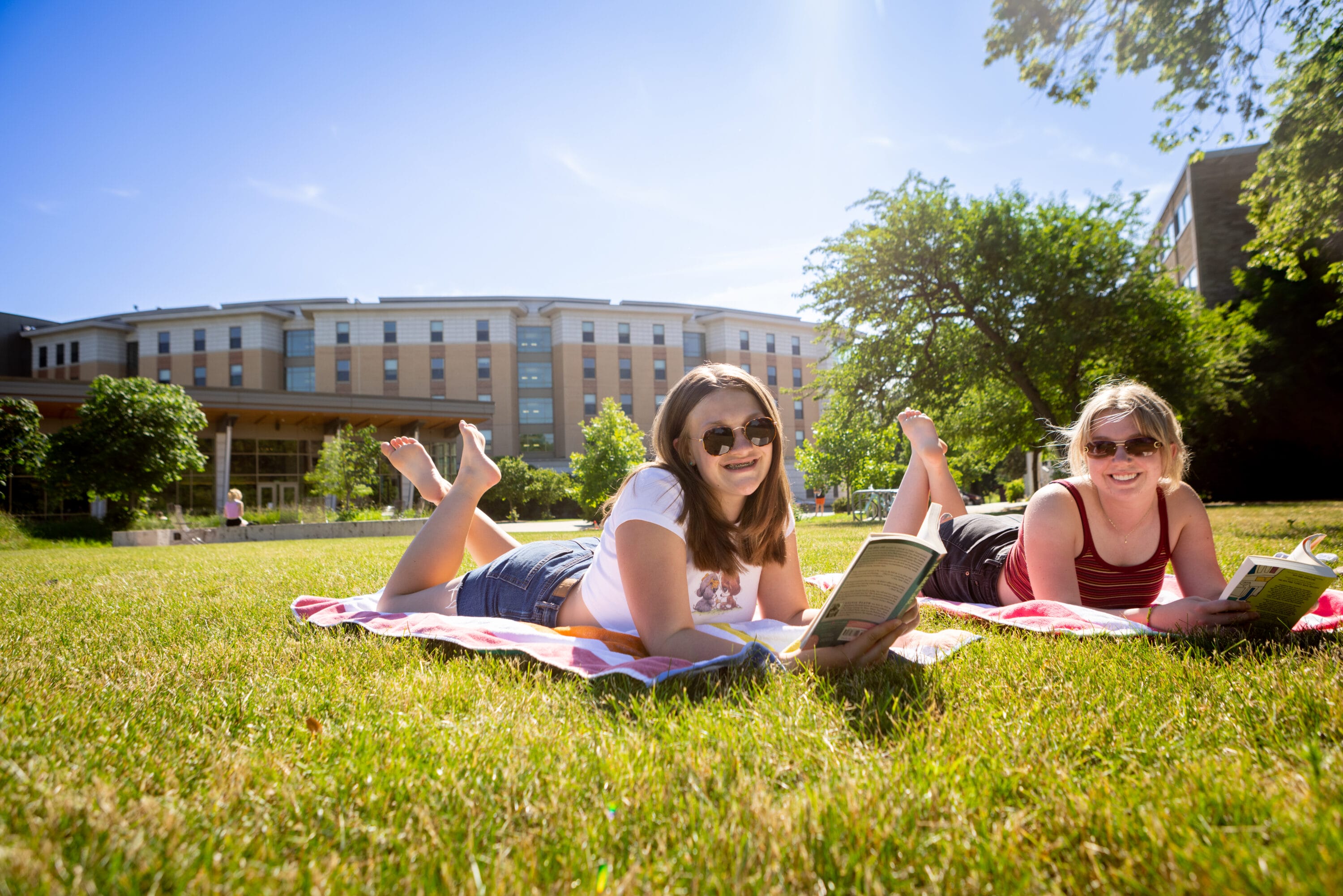 Two UW-Madison students on the grass outside the Kohl center.