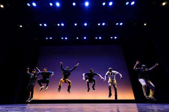 Dancers on stage jumping in sync