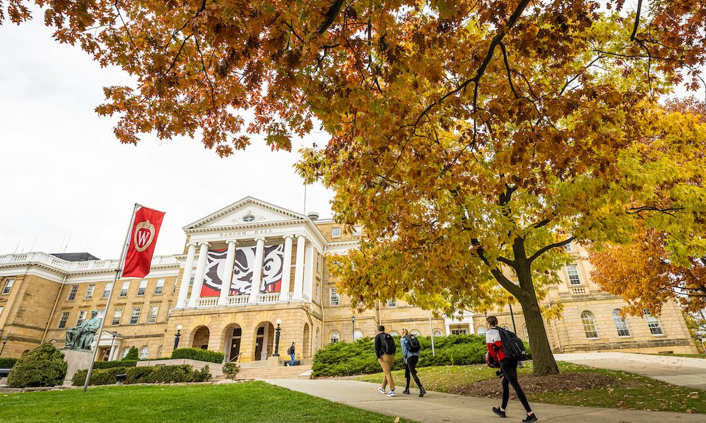 Pedestrians and students walk among the colors of the fall leaves near Bascom Hall at the University of Wisconsin–Madison during autumn